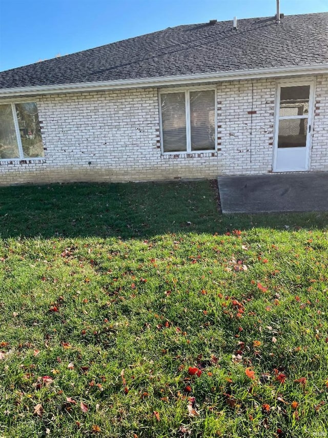 view of side of home featuring a lawn and a patio