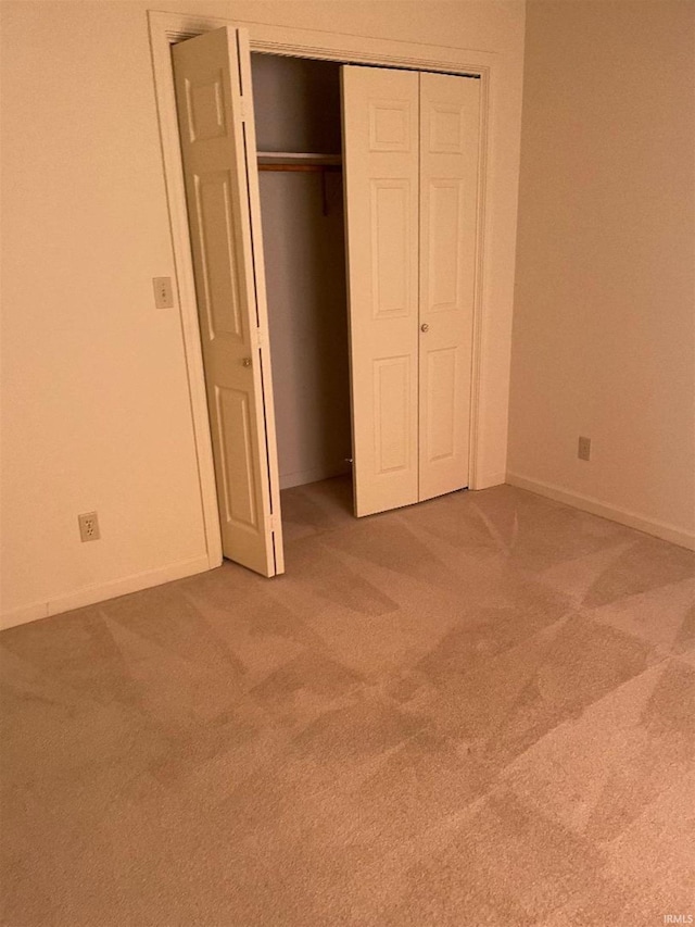 unfurnished bedroom featuring carpet and a closet