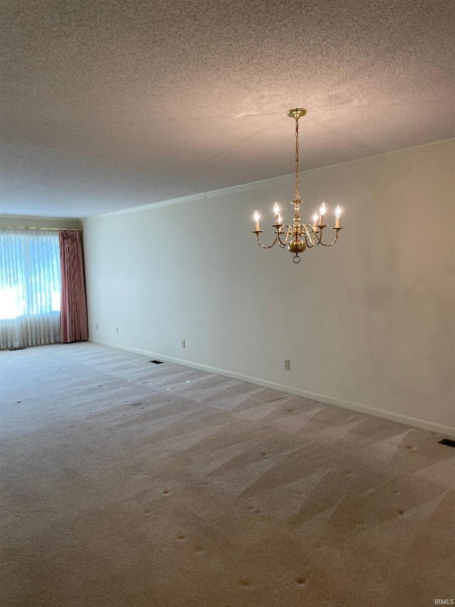 spare room with carpet, a textured ceiling, and an inviting chandelier