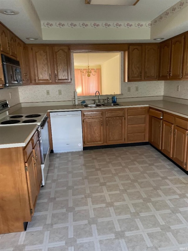 kitchen with white dishwasher, an inviting chandelier, stainless steel range with electric stovetop, and sink