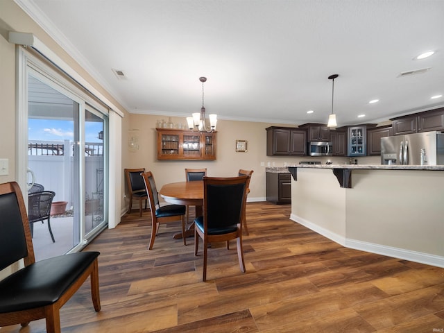 dining room featuring an inviting chandelier, dark hardwood / wood-style flooring, and ornamental molding