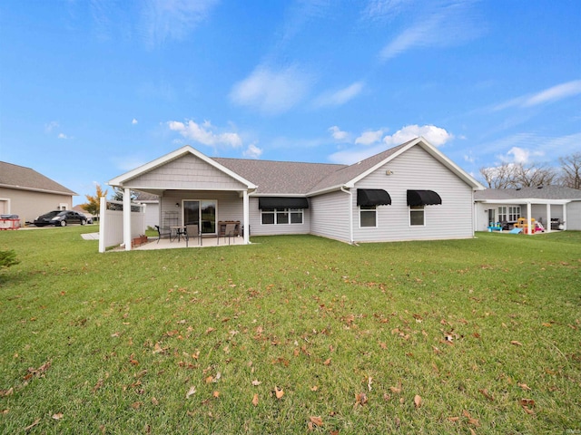 rear view of house with a patio and a yard