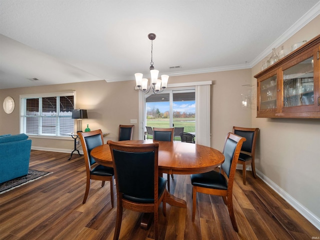 dining room with ornamental molding, a notable chandelier, and dark hardwood / wood-style floors