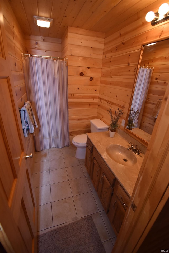 bathroom featuring toilet, tile patterned floors, wooden walls, wooden ceiling, and vanity