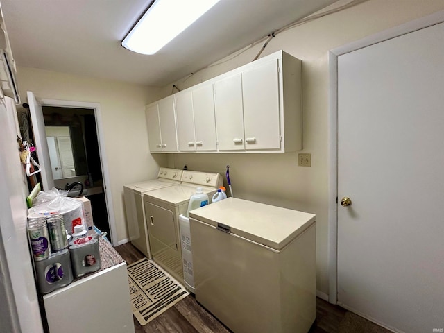 washroom with washing machine and dryer, cabinets, and dark wood-type flooring