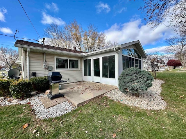 rear view of house with a patio area, a sunroom, and a yard