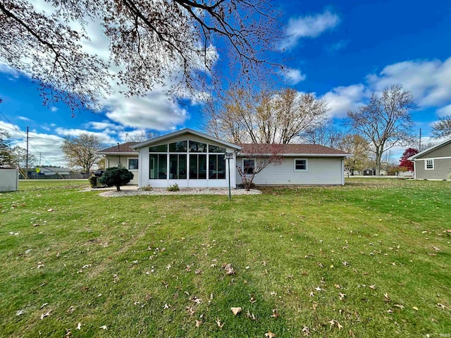 rear view of property with a sunroom and a yard