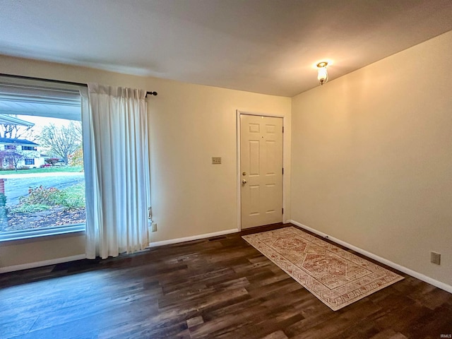 unfurnished room with dark wood-type flooring