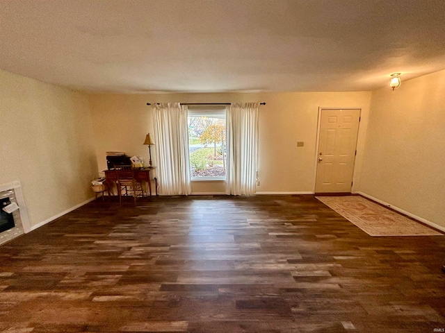 interior space with dark hardwood / wood-style flooring, a textured ceiling, and heating unit