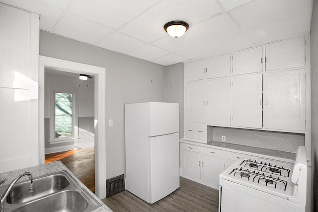 kitchen with white cabinetry, sink, a drop ceiling, white appliances, and dark hardwood / wood-style flooring