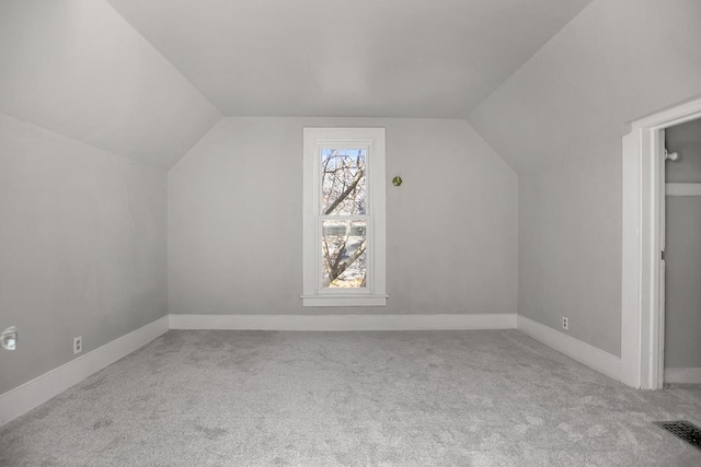 bonus room featuring light colored carpet and vaulted ceiling