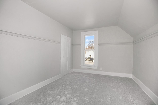 bonus room with vaulted ceiling and carpet