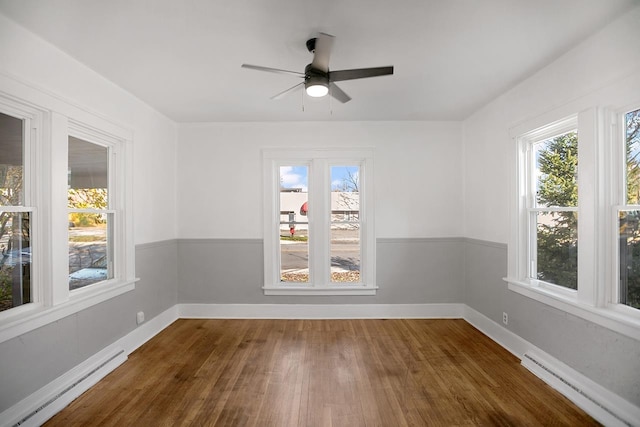 empty room with a baseboard radiator, dark hardwood / wood-style floors, and ceiling fan