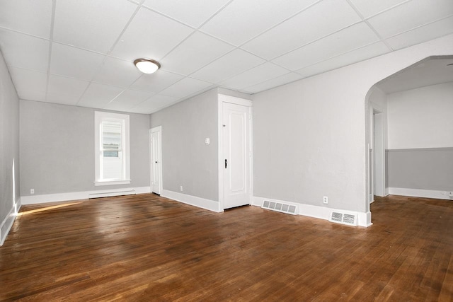 spare room featuring a drop ceiling, hardwood / wood-style floors, and a baseboard radiator