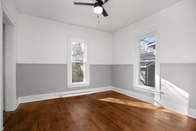 unfurnished room featuring a wealth of natural light, hardwood / wood-style flooring, and a baseboard radiator