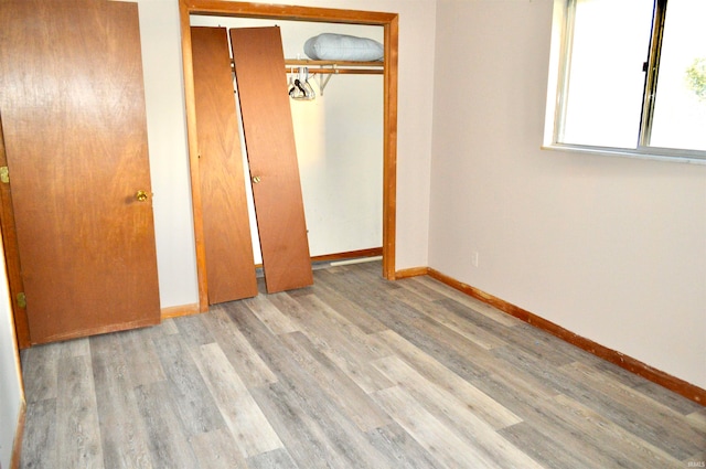 unfurnished bedroom featuring a closet and light wood-type flooring