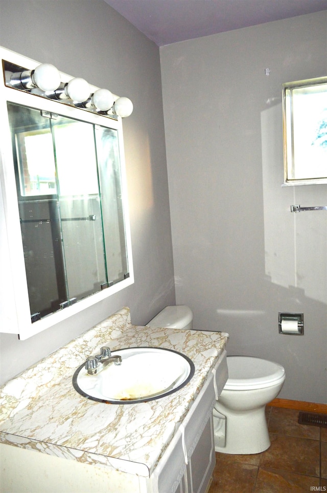 bathroom with tile patterned flooring, vanity, and toilet