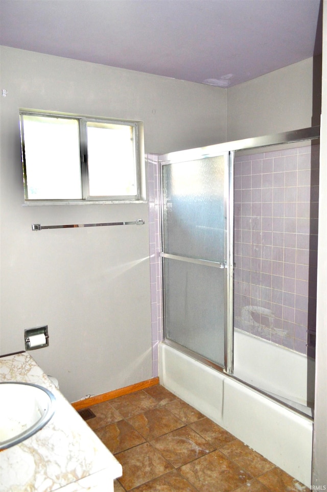 bathroom featuring shower / bath combination with glass door and vanity