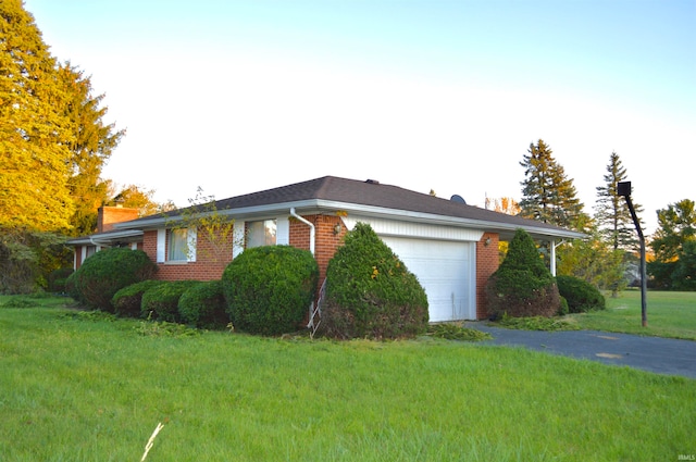 view of property exterior featuring a garage and a lawn