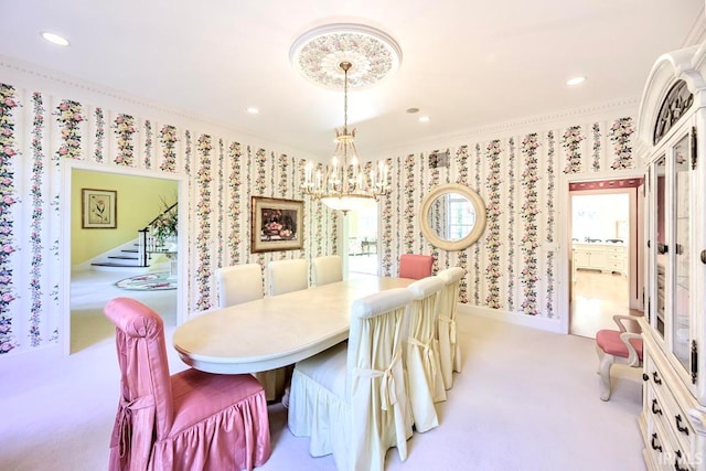 dining area featuring an inviting chandelier, light colored carpet, and ornamental molding