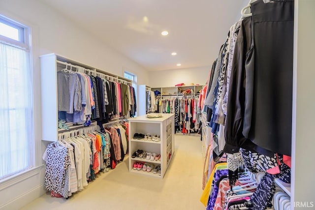 walk in closet featuring light colored carpet