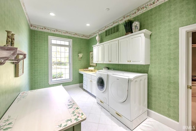 laundry area featuring cabinets, washer and dryer, and light tile patterned floors