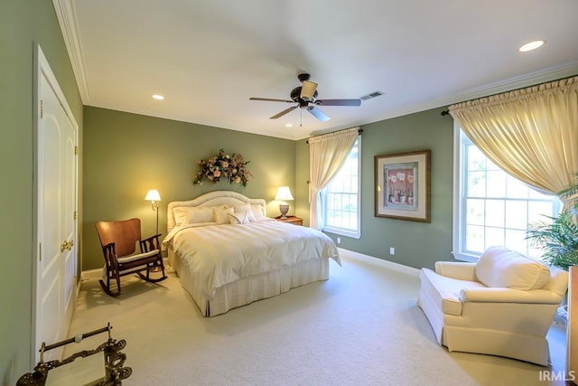 carpeted bedroom featuring ceiling fan, multiple windows, and ornamental molding