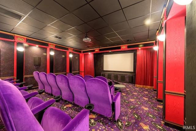 cinema with a paneled ceiling and carpet