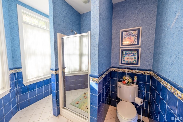 bathroom featuring a shower, tile patterned floors, toilet, and tile walls