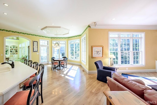 dining area featuring light hardwood / wood-style flooring, ornamental molding, and plenty of natural light