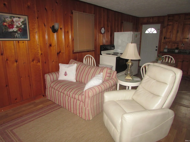 living room with wood walls and wood-type flooring