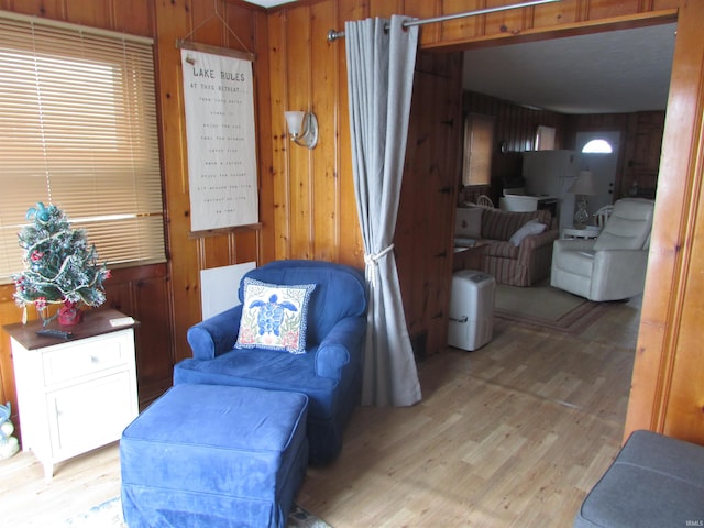 living area with wooden walls and light wood-type flooring