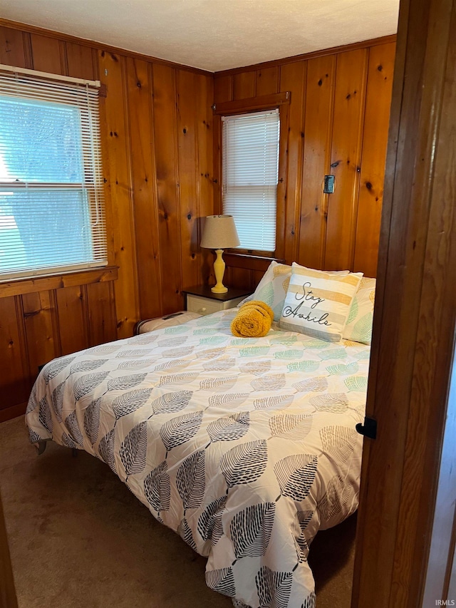 bedroom with wooden walls and carpet floors