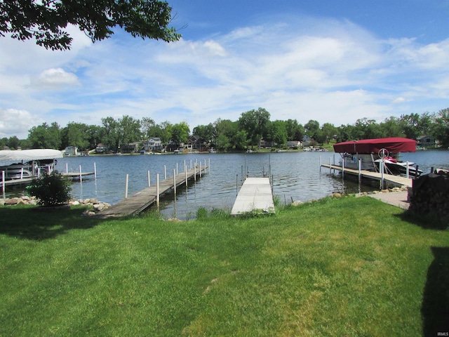 view of dock featuring a water view and a yard