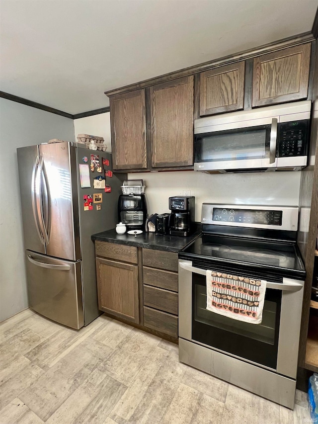 kitchen featuring stainless steel appliances, dark brown cabinets, and light wood-type flooring