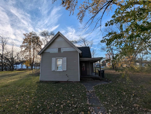 view of home's exterior with a lawn and a porch