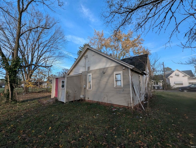 view of side of home with a yard