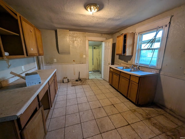 kitchen with sink, light tile patterned flooring, and a textured ceiling