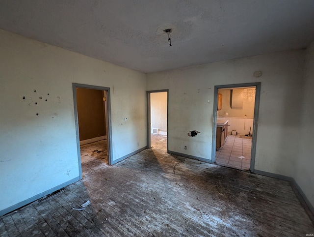 unfurnished bedroom featuring connected bathroom and a textured ceiling