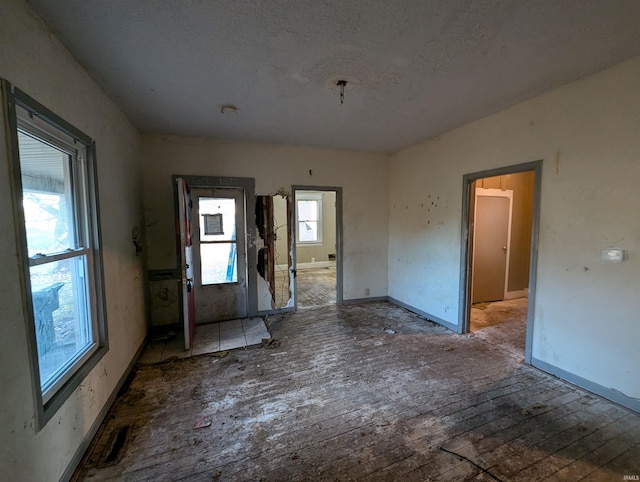 unfurnished room with hardwood / wood-style floors and a textured ceiling