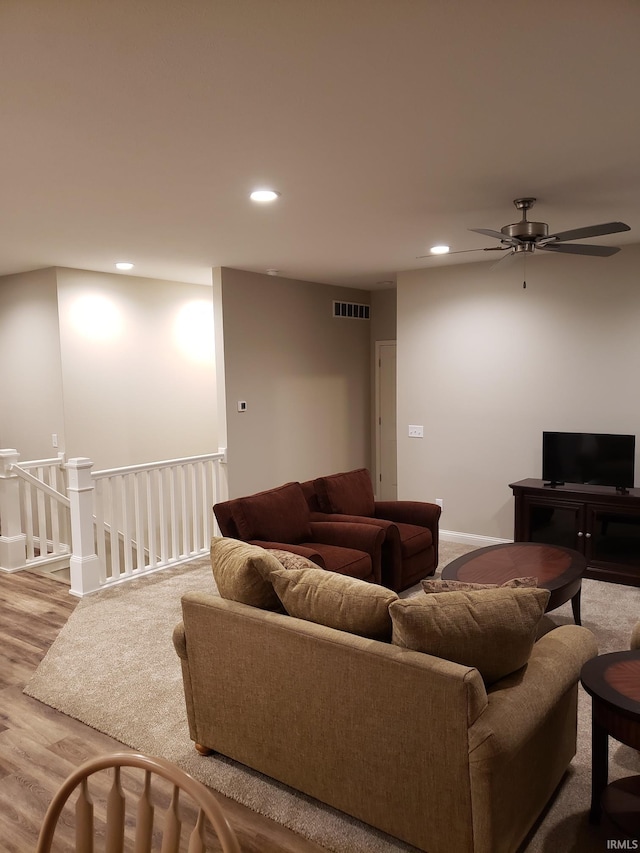 living room featuring hardwood / wood-style floors and ceiling fan