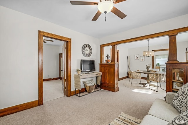 carpeted living room featuring ceiling fan with notable chandelier