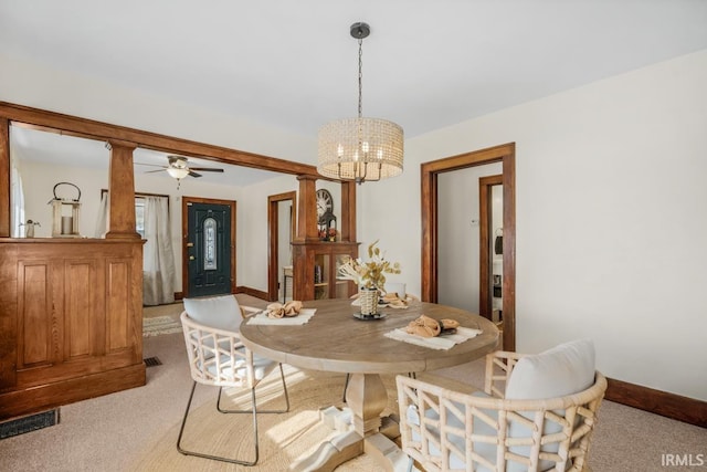 carpeted dining space with ceiling fan with notable chandelier