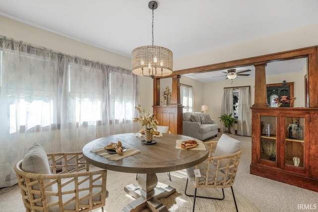 carpeted dining room featuring ceiling fan with notable chandelier