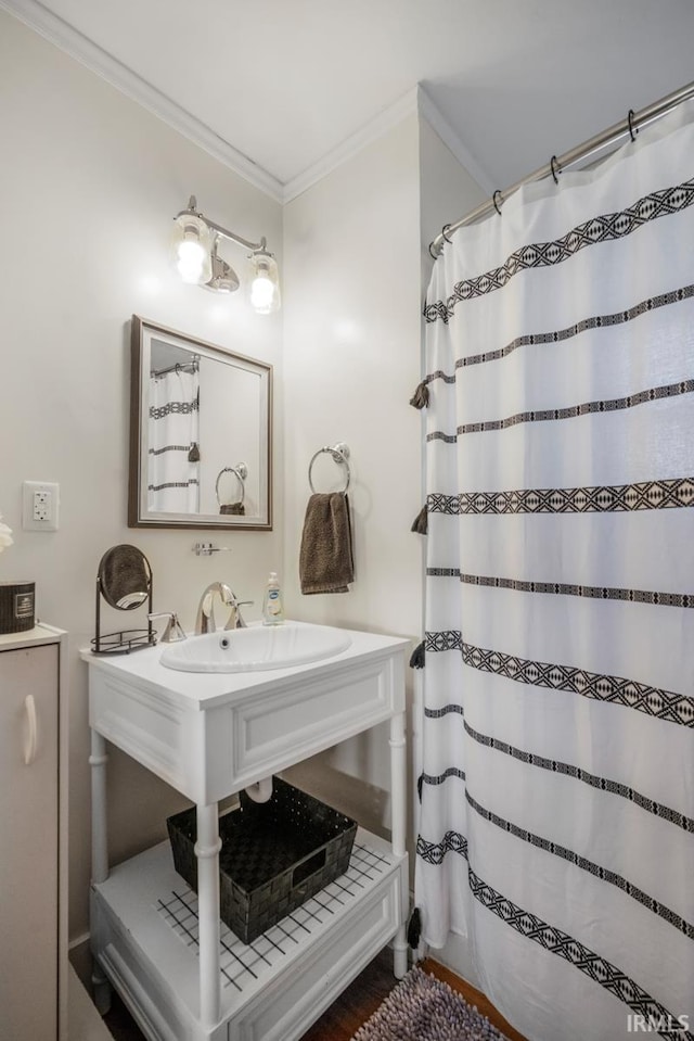 bathroom featuring a shower with shower curtain, hardwood / wood-style flooring, sink, and ornamental molding