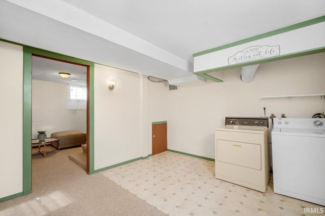 laundry room with separate washer and dryer and light carpet