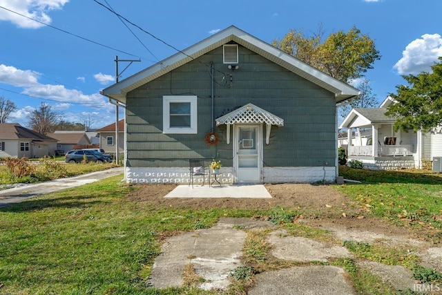 rear view of property featuring cooling unit and a yard