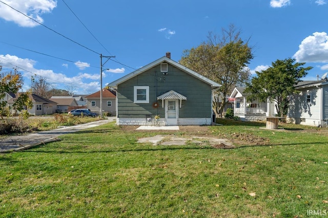 back of house featuring a lawn