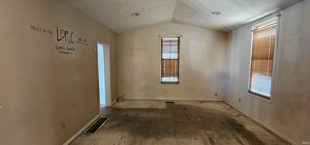 spare room featuring lofted ceiling and a textured ceiling