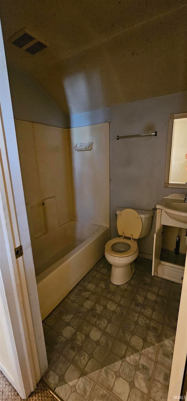 bathroom with sink, toilet, and vaulted ceiling